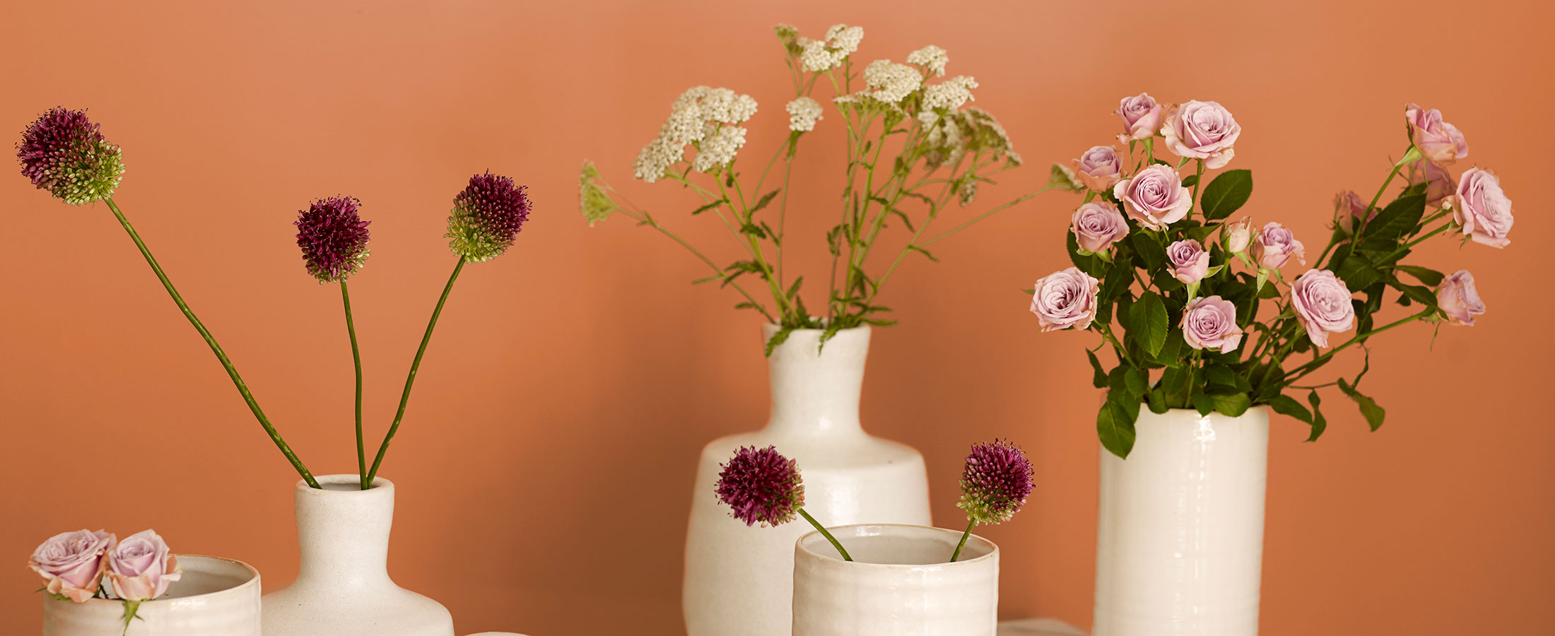 Oransj bakgrunn med blomster i vaser